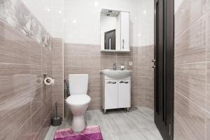 a bathroom with a toilet and a sink and a mirror at Sun City Apart Hotel in Dnipro +68 photos