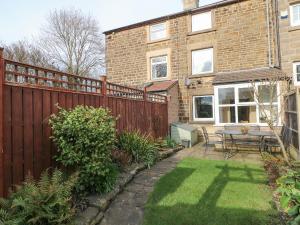 a backyard with a wooden fence and a table at Fieldside in Belper