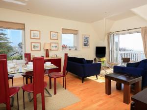 a living room with a couch and a table and chairs at 6 Grafton Towers in Salcombe