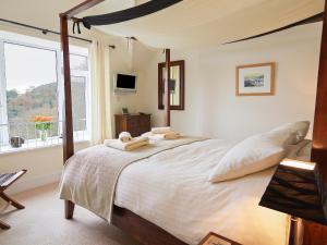 a bedroom with a large bed with a large window at 6 Grafton Towers in Salcombe
