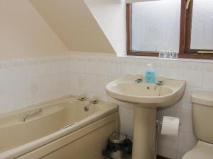 a bathroom with a sink and a tub and a toilet at Waggoners Cottage in Montgomery