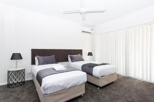 Dos camas en una habitación con paredes blancas. en Wagga Apartments #4, en Wagga Wagga