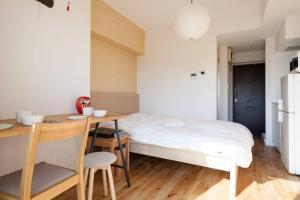 um quarto com uma cama, uma mesa e uma cozinha em Dwell Urban 6C em Tóquio