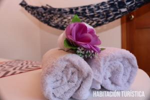 een stel handdoeken met een paarse bloem erop bij Hotel Colonial - Honda - in Honda