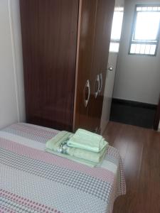 uma cama com duas toalhas dobráveis em cima em Quartos Masculino - Romas House em Itu