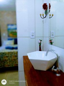 a bathroom with a sink with flowers on the wall at Suites Casa De Ban in Lençóis