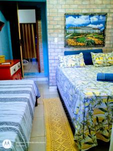 a bedroom with two beds and a painting on the wall at Suites Casa De Ban in Lençóis