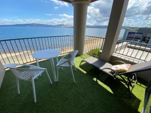 a balcony with a table and chairs and the ocean at Boulevard Waters in Taupo