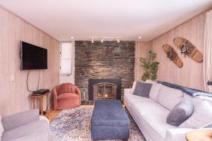 a living room with a couch and a fireplace at Classic Stowe Ski Chalet chalet in Stowe