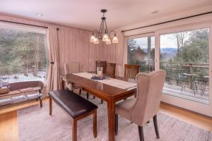 a dining room with a table and chairs and a large window at Classic Stowe Ski Chalet chalet in Stowe