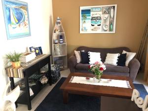 a living room with a couch and a coffee table at Beachhouse Bed and Breakfast in Redcliffe