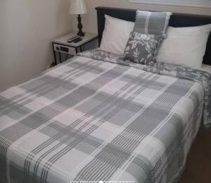 a bed with a plaid blanket and a night stand at Cozy 1 BR Efficiency Apt close to TTU and Downtown in Cookeville