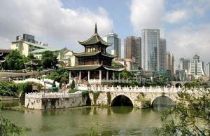 a building with a bridge over a river in a city at 7Days Inn Guiyang Jinyang Century City Shopping Center in Guiyang
