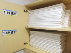 貴陽市にある7Days Inn Guiyang Ergezhaiの棚に白紙タオルを積み重ねる