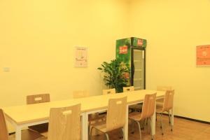 um quarto com uma mesa e cadeiras e uma máquina de refrigerante em 7Days Inn Guiyang Ergezhai em Guiyang