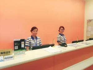 two people sitting at a counter in an office at 7Days Inn Guiyang Ergezhai in Guiyang