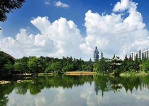 un lago in un parco con una città sullo sfondo di 7 Days Guiyang Century City Convention and Exhibition City a Guiyang