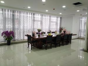 uma sala de jantar com uma mesa longa e cadeiras em 7 Days Guiyang North Station em Guiyang