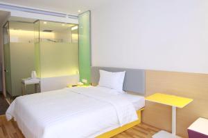 Un dormitorio con una gran cama blanca y un espejo. en 7 Days Guiyang North Station, en Guiyang