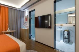 昆明市にあるMengjing Xiyue Hotelのベッドルーム1室(ベッド1台、テレビ付)