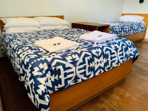 a bedroom with two beds with blue and white sheets at Coonalpyn Hotel in Coonalpyn