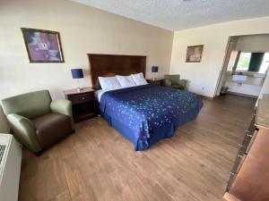 Habitación de hotel con cama y silla en Coral Roc Motel, en Florida City