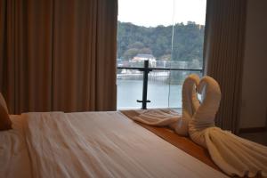 a hotel room with a bed with a window at Lotus Lake Residence in Kandy
