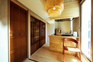 a kitchen with a wooden counter and a chair at Shibuya神宮前 DAICHI&SOTEN in Tokyo