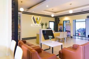 a lobby of a car dealership with chairs and a table at Baan Phor Phan Hotel in Khon Kaen