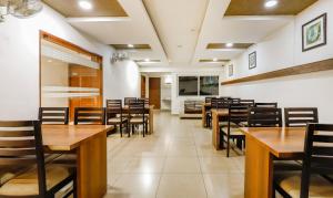 a dining room with wooden tables and chairs at The Mount City Near US Consulate in Chennai