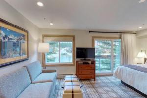 a bedroom with a bed and a couch and a tv at Mountain Valley Lodge in Breckenridge