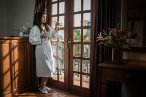 a woman in a robe standing in front of a door at Hotel Shwe Yee in Yangon