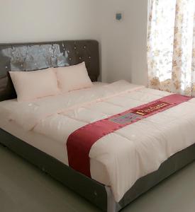 een bed in een slaapkamer met een grote witte sprei bij Red Perdana in Pontianak