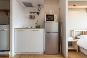 a small kitchen with a refrigerator and a bed at Dwell Urban 7C in Tokyo