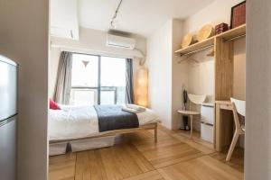 a small bedroom with a bed and a window at Dwell Urban 7C in Tokyo