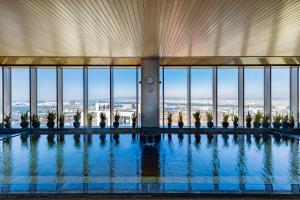 a swimming pool in a building with a view of the city at Hotel Keihan Universal Tower in Osaka