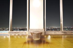 a room with a view of a city at night at Hotel Keihan Universal Tower in Osaka