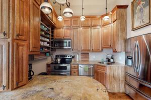 a kitchen with wooden cabinets and a large wooden table at Jarvis #303 in Durango