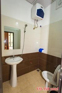 a bathroom with a sink and a mirror and a toilet at Van Anh Motel in Cốc Lếu