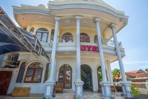 a large house with a balcony on top of it at OYO 2848 Senaz Guesthouse in Mataram