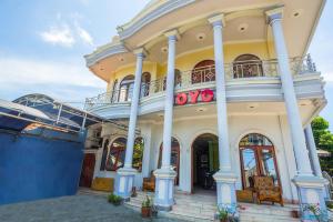 a large yellow building with a balcony at OYO 2848 Senaz Guesthouse in Mataram