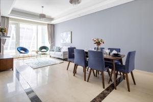 a dining room with a table and blue chairs at Frank Porter - Mon Reve in Dubai