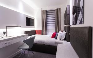 a bedroom with a bed and a desk and a sink at Henley House Hotel in London