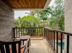 un balcón de una casa con mesa y sillas en Ruby Nusa Dua Bali, en Nusa Dua