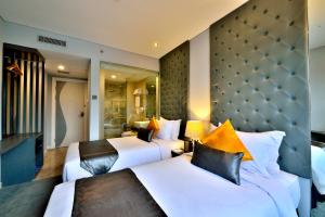 Tempat tidur dalam kamar di Serela Cihampelas by KAGUM Hotels