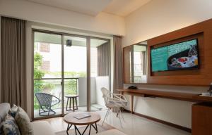 a living room with a tv on a wall at MERUSAKA Nusa Dua in Nusa Dua