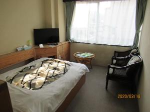 Dormitorio con cama, escritorio y TV en Weekly Mansion Ise No.6 en Ise