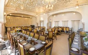 a large dining room with tables and chairs at The Jai Bagh Palace in Jaipur