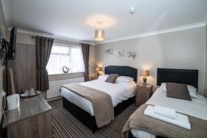 a hotel room with two beds and a window at The Causeway Guest House in March