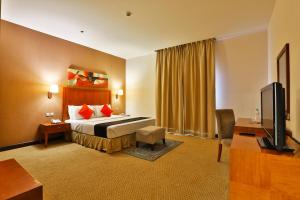 a hotel room with a bed and a television at مينا بلازا الطائف Mena Plaza Taif in Taif